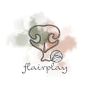 On peut voir une pelote de laine de laquelle sort un fil qui dessine une truffe de chien. En arrière plan on voit deux couleurs qui s'entremêlent. Du vert et du beige orangé.